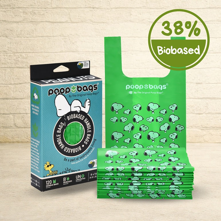 The Original Poop Bags Peanuts Snoopy 120-count box beside a stack of green biobased dog poop bags with handles, unscented.