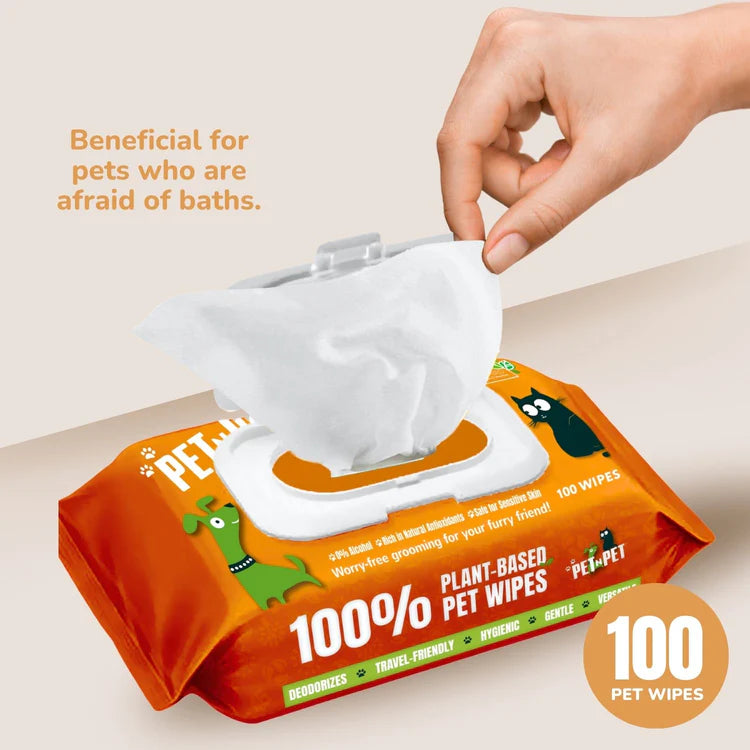 Pet n Pet plant-based pet wipe being pulled from orange package with "Beneficial for pets who are afraid of baths" messaging and 100-count designation.